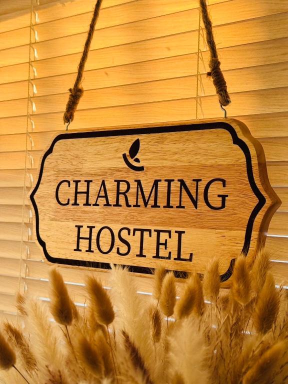 a sign that readschanting hostel hanging above wheat ears at Charming Hostel in Bangkok