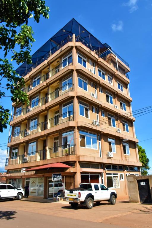 a large building with cars parked in front of it at East Point Hotel Moshi in Moshi