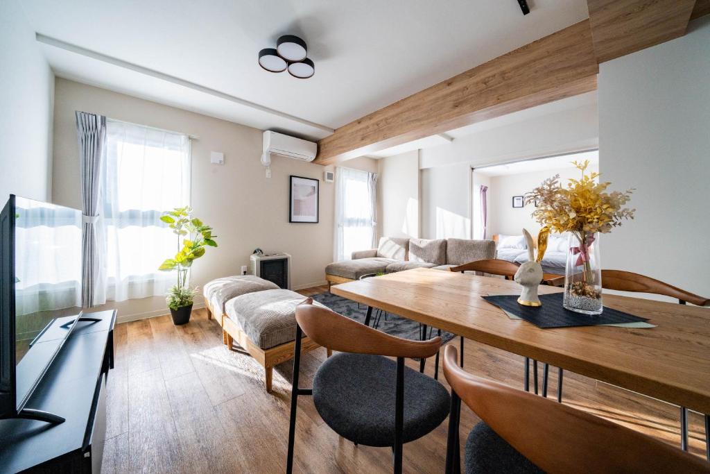 a living room with a wooden table and chairs at Zabo Hills 203 in Sapporo