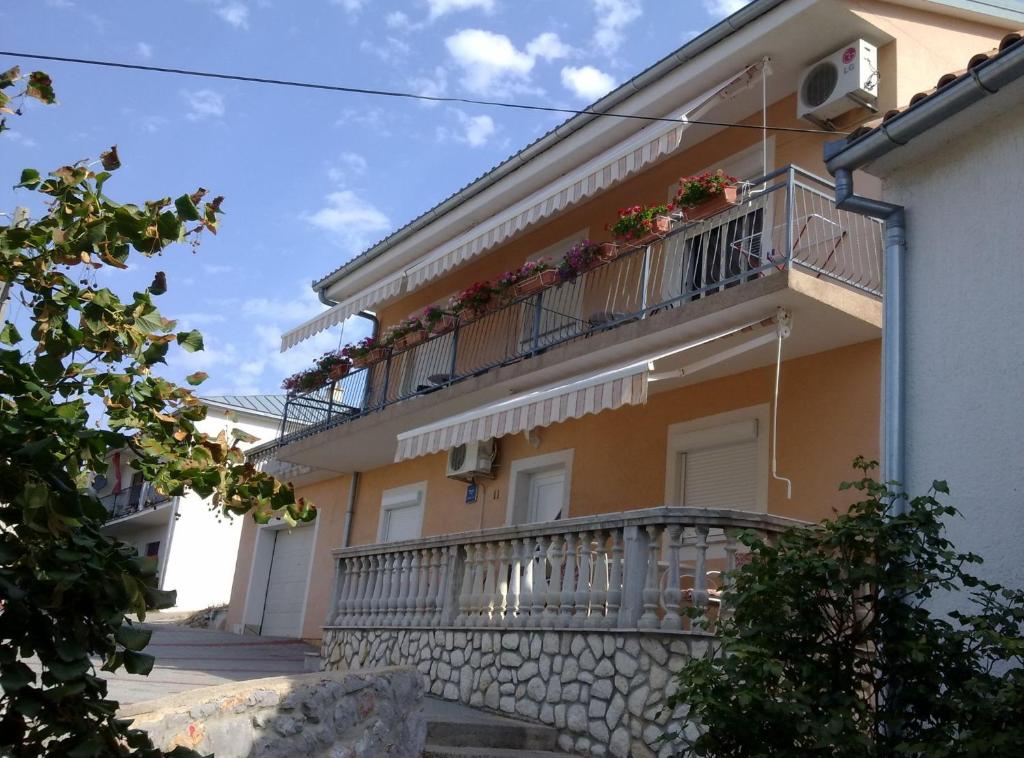 un bâtiment avec un balcon fleuri dans l'établissement Apartments Bionda, à Novi Vinodolski