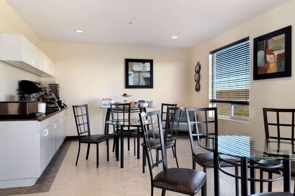 a kitchen and dining room with a table and chairs at Days Inn by Wyndham Grande Prairie in Grande Prairie