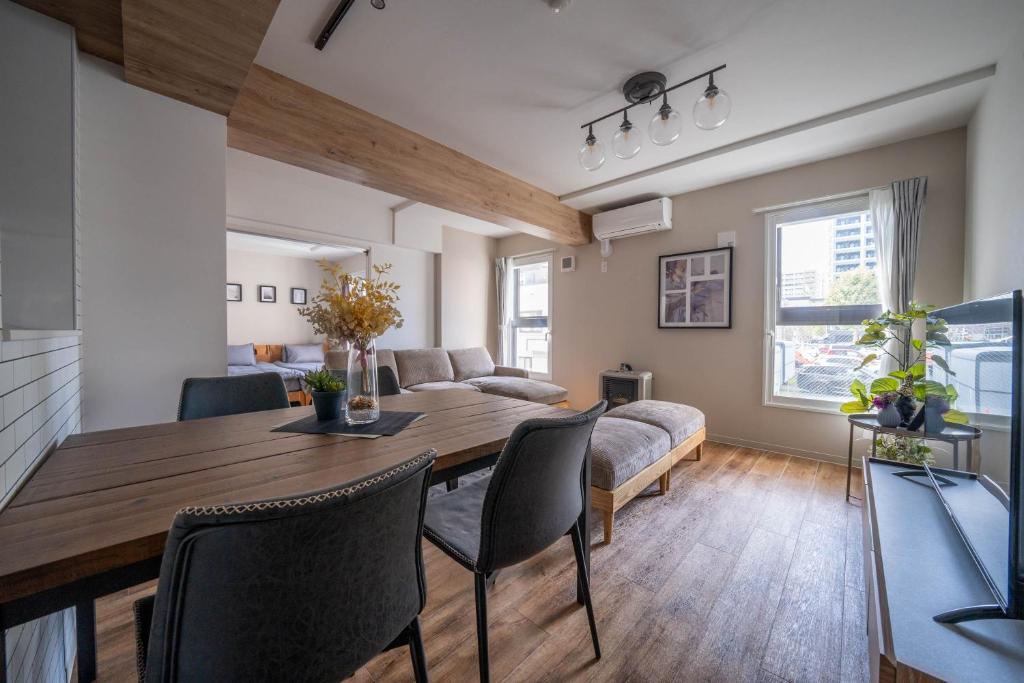 a living room with a wooden table and chairs at Zabo Hills 205 in Sapporo