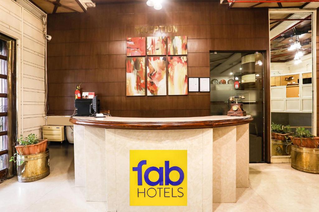 a restaurant counter with a fico hotel sign on it at FabHotel Darshan Tower in Nagpur