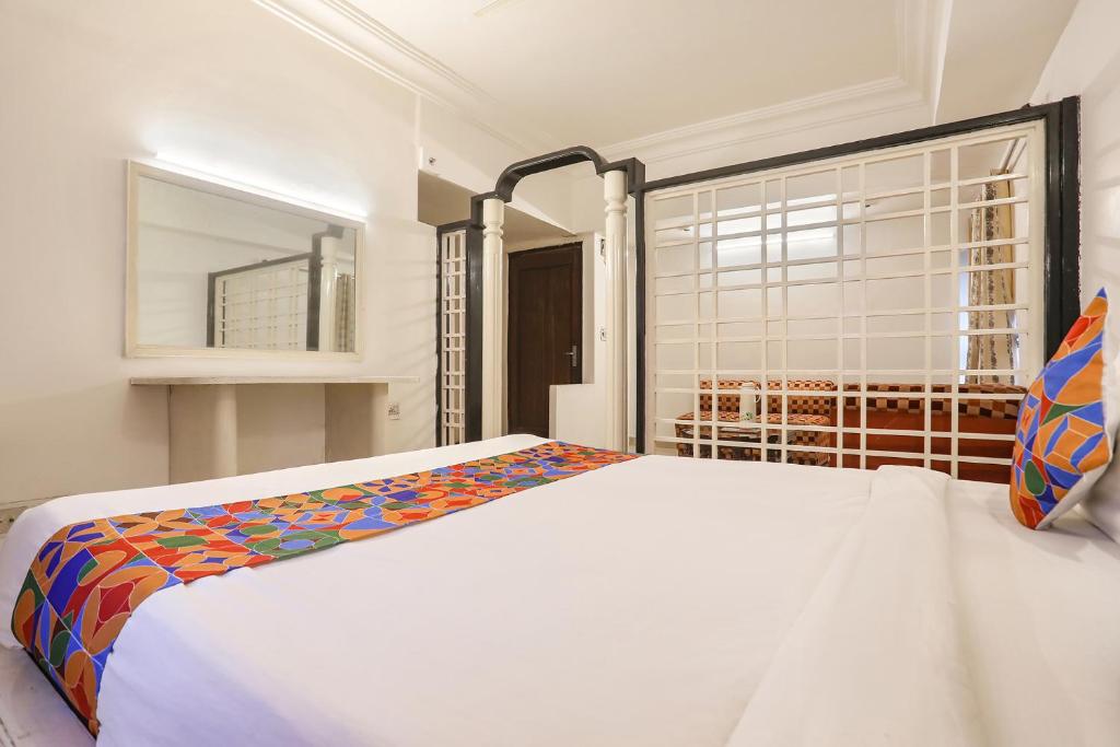 a bedroom with a white bed and a window at FabHotel Darshan Tower in Nagpur