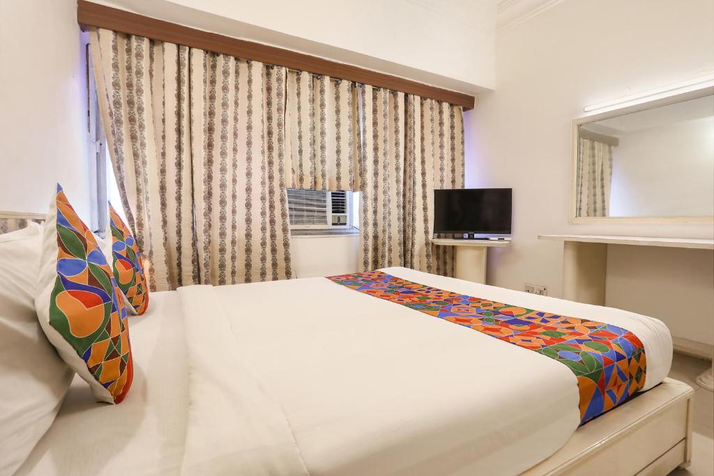 a bedroom with a large white bed in front of a window at FabHotel Darshan Tower in Nagpur