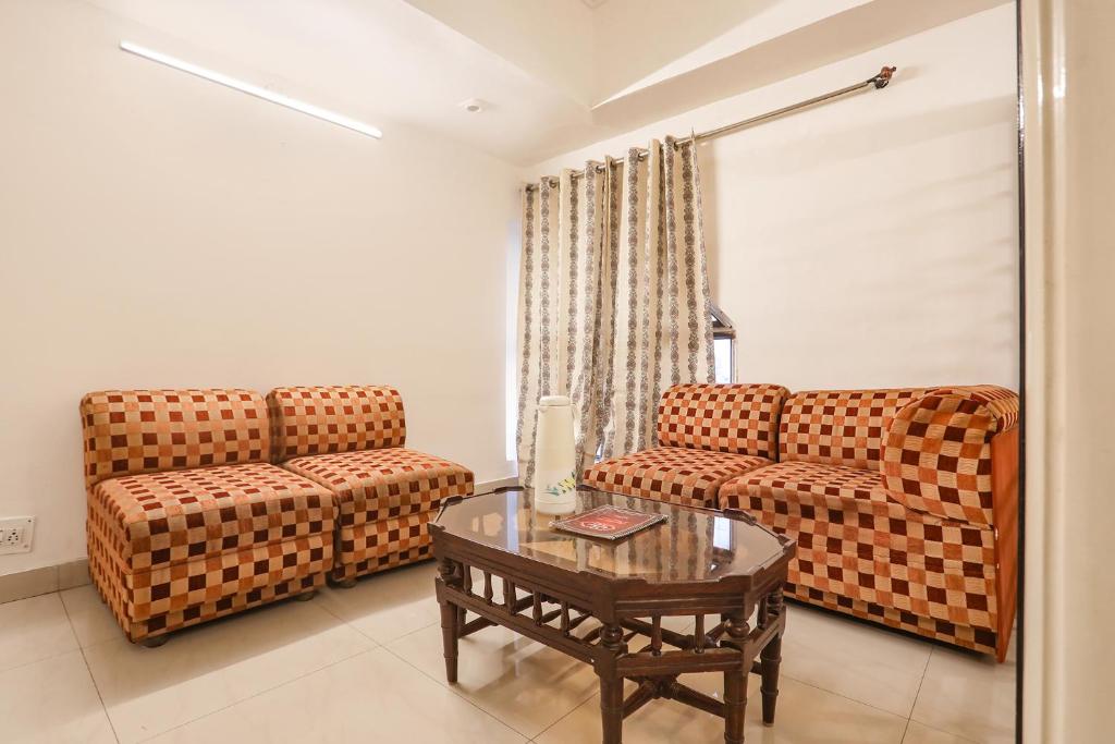 a living room with two couches and a coffee table at FabHotel Darshan Tower in Nagpur