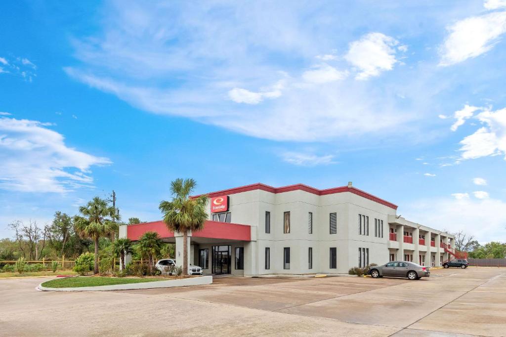 un edificio con un'auto parcheggiata in un parcheggio di Econo Lodge Inn & Suites a Channelview