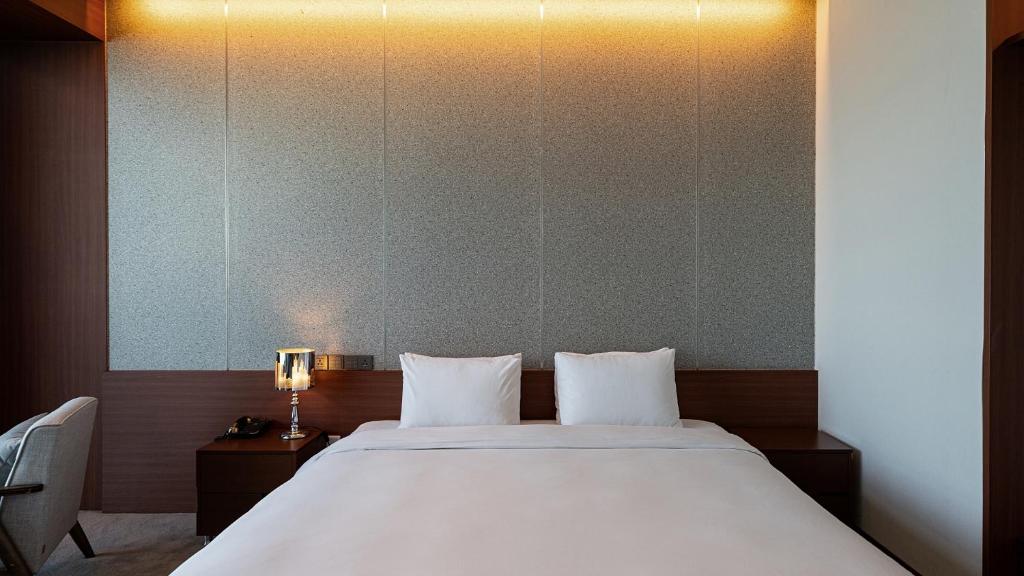 Uma cama ou camas num quarto em Hotel JCS Yeosu