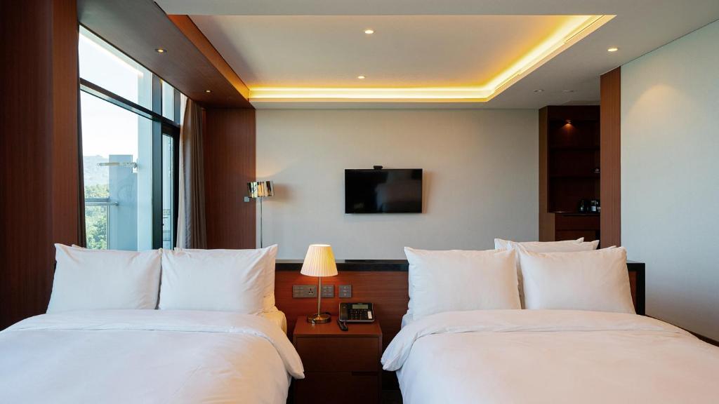 Uma cama ou camas num quarto em Hotel JCS Yeosu