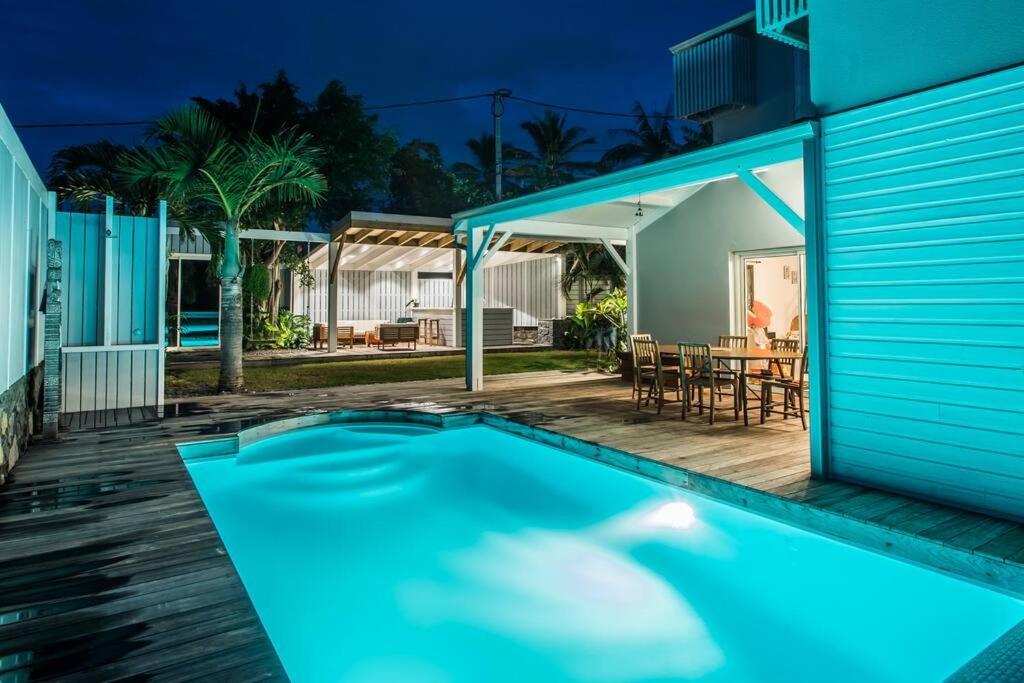una piscina frente a una casa en Villa meublé Tourisme 4 etoiles Sous le Ficus piscine chauffée - Ouest Lagon, en Saint-Paul