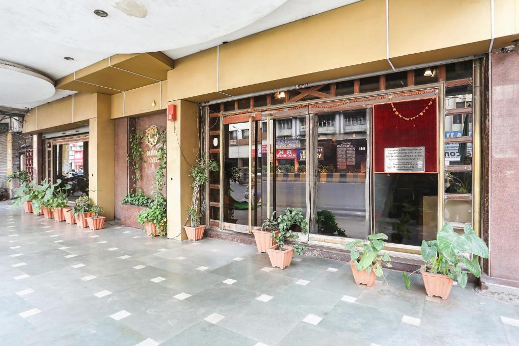 a building with potted plants in front of a store at FabHotel Darshan Tower in Nagpur