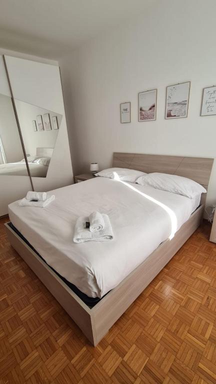 a bedroom with a large bed with white sheets at Eleonora's House in Trieste