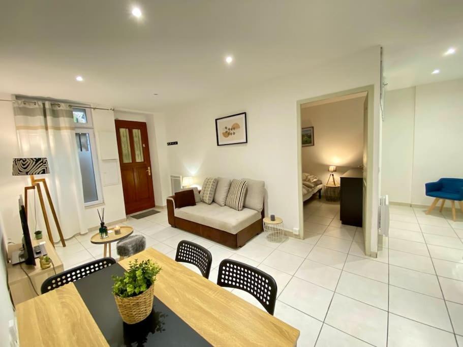 un salon avec un canapé, une table et des chaises dans l'établissement Charmant T1 au Cœur de Nimes, à Nîmes