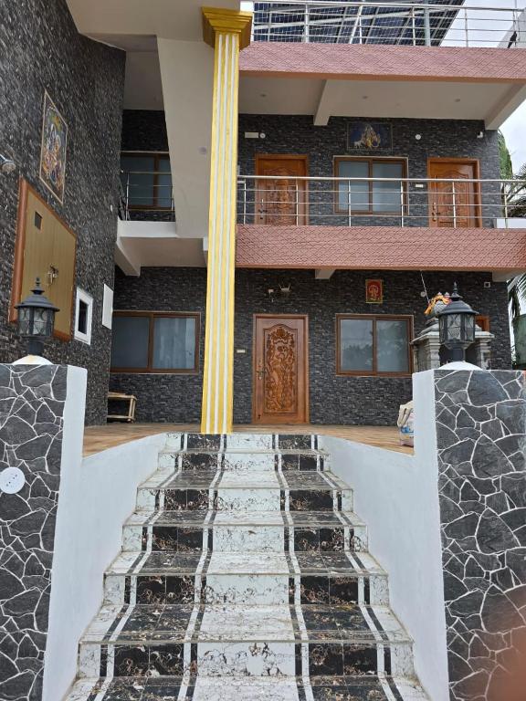 un edificio con colonna e scale di fronte ad esso di House Of Suhama a Mamallapuram