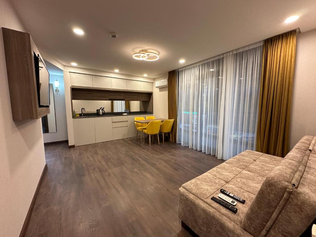 a living room with a couch and a kitchen at Beautiful apartments near the sea Adlia street in Batumi
