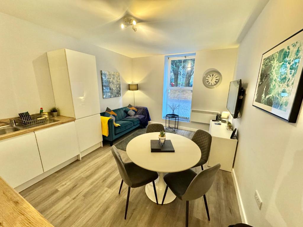 a kitchen and a living room with a table and chairs at Two Bedroom Apartment - Heart of Bournemouth - Free Parking - Sleeps 6 - Close to Town and Beach in Bournemouth