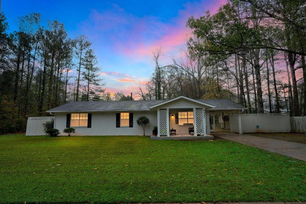 una piccola casa bianca con un cortile verde di Family-Friendly 3BR Oasis in Powder Springs home a Powder Springs