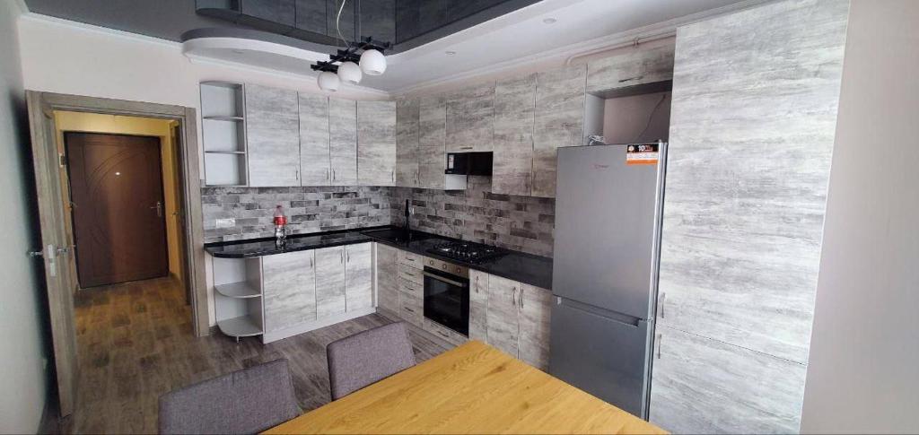 a kitchen with a refrigerator and a counter top at ATLANT luxury Family Apart поряд з ТЦ ДЕПОТ, БЕЗКОНТАКТНЕ ЗАСЕЛЕННЯ in Chernivtsi