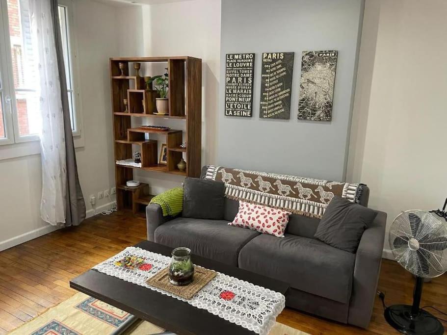 un salon avec un canapé et une table basse dans l'établissement Parc Montsouris - Longue durée, à Paris