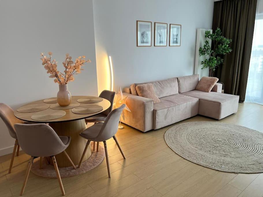 a living room with a couch and a table with chairs at Silk Haven - Central Apartment in Iaşi