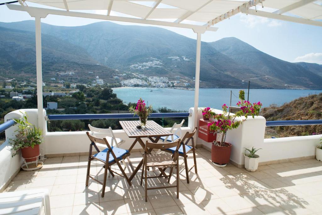 einen Balkon mit einem Tisch und Stühlen sowie Aussicht in der Unterkunft Amorgi Studios in Aegiali