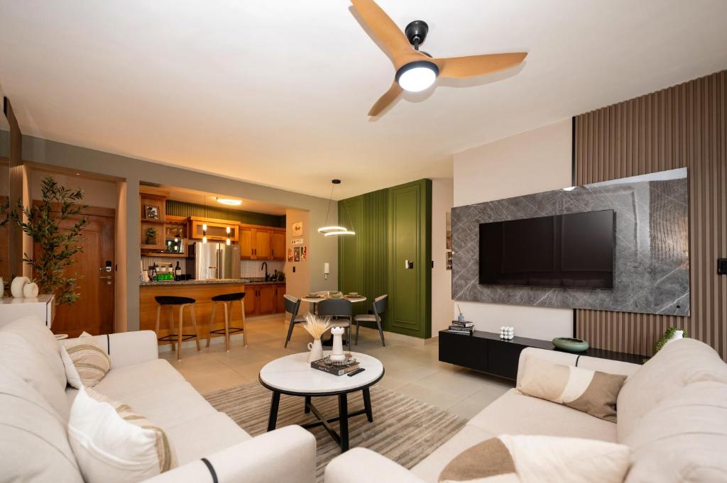a living room with a white couch and a flat screen tv at Pool & Gym - 10min Aeropuerto y HOMS - Dream Stay in Santiago de los Caballeros
