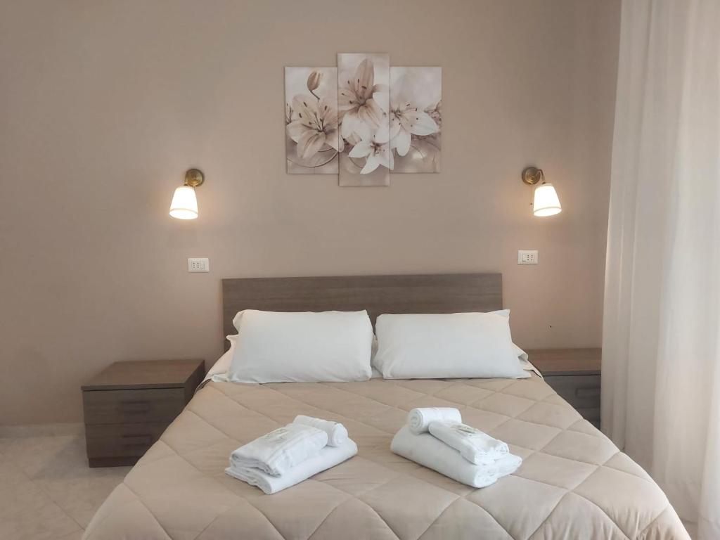a bedroom with a bed with two towels on it at SUITE - 2 Camere da Letto - Fiumicino Aeroporto e Fiera in Fiumicino