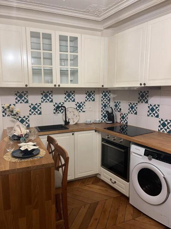 BerthouvilliersCozy appartement near Opera and Galeries Lafayette Haussmann的配有白色橱柜和洗碗机的厨房
