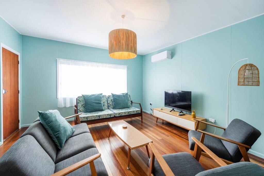 Una sala de estar con un sofá y un televisor. en Little Banksia 1 - LJHooker Yamba, en Yamba