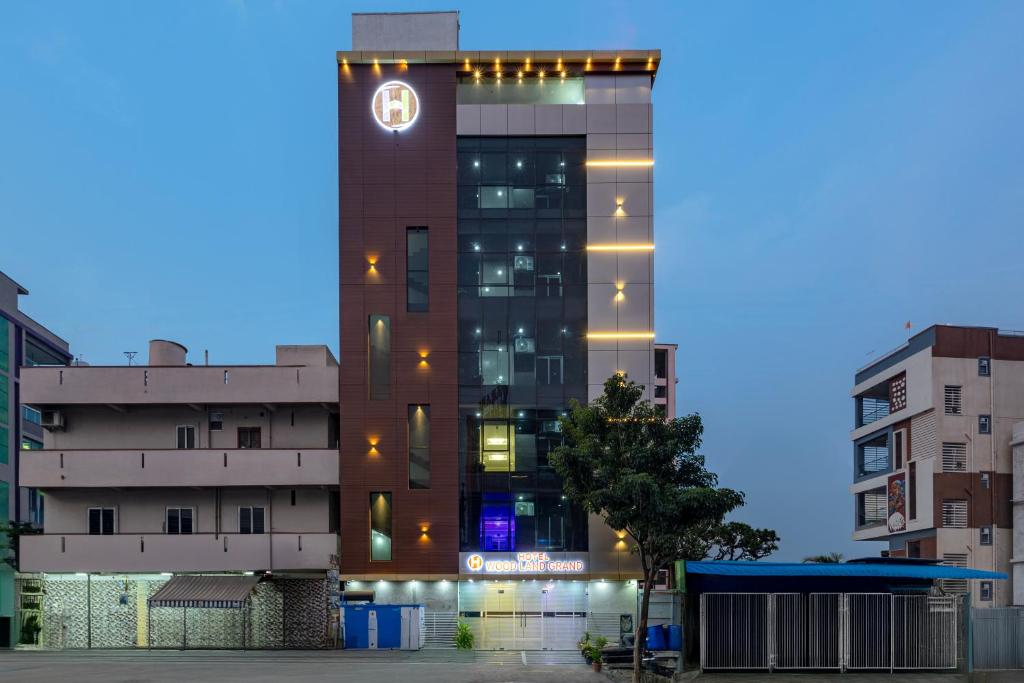Un edificio alto con un reloj a un lado. en Hotel wood land grand, en Guntūr