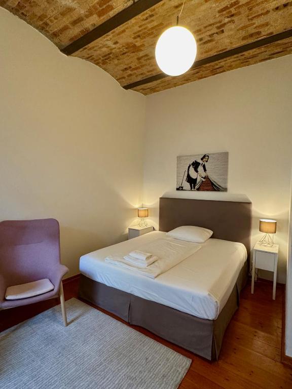 a bedroom with a bed and a purple chair at berlincity in Berlin