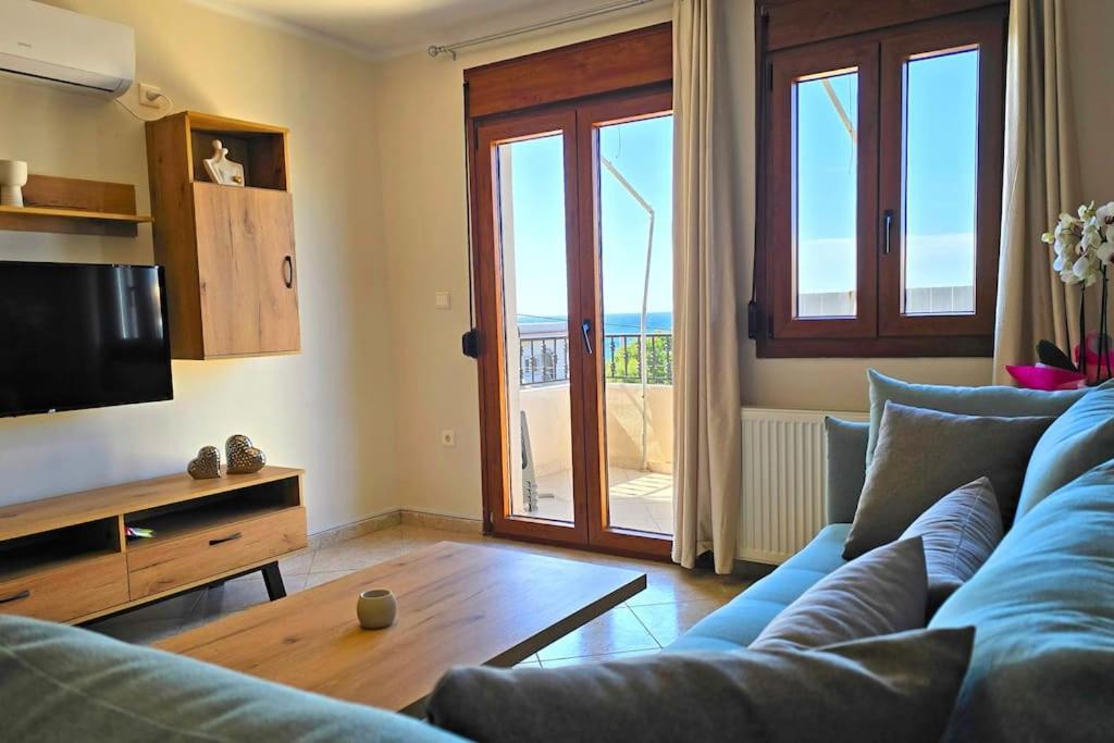 a living room with a blue couch and a television at Calliestia 7 in Chios