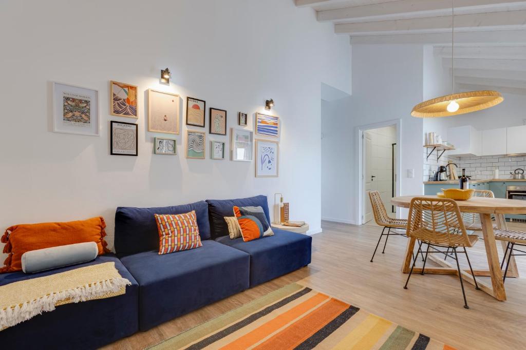un soggiorno con un divano blu e un tavolo di Casa Maria Rota ad Aljezur