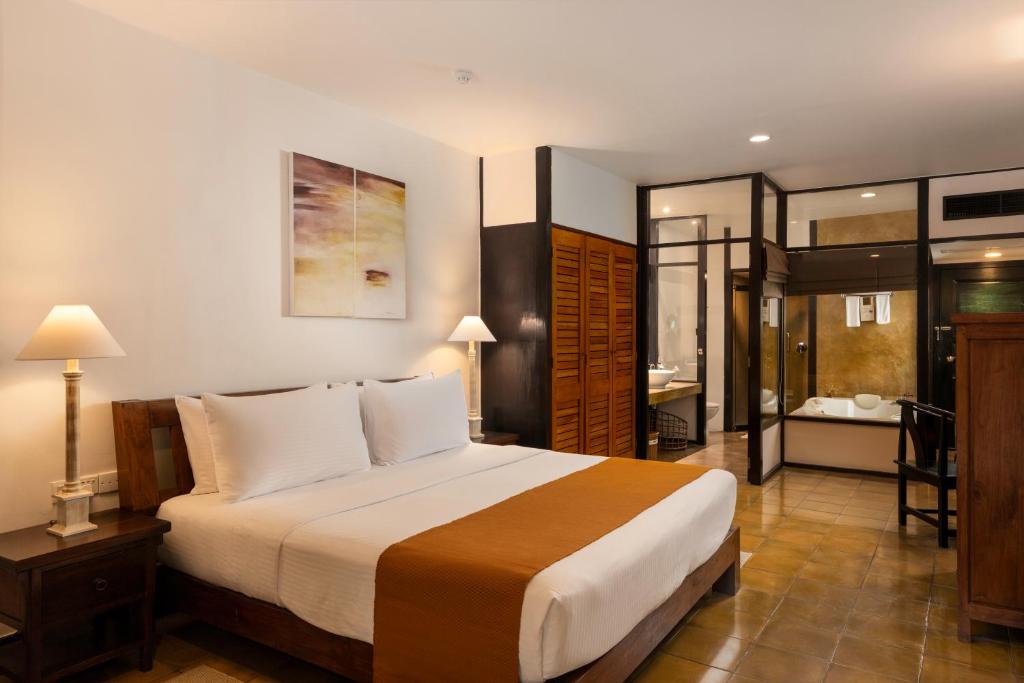 a bedroom with a large bed and a bathroom at Jetwing Beach in Negombo