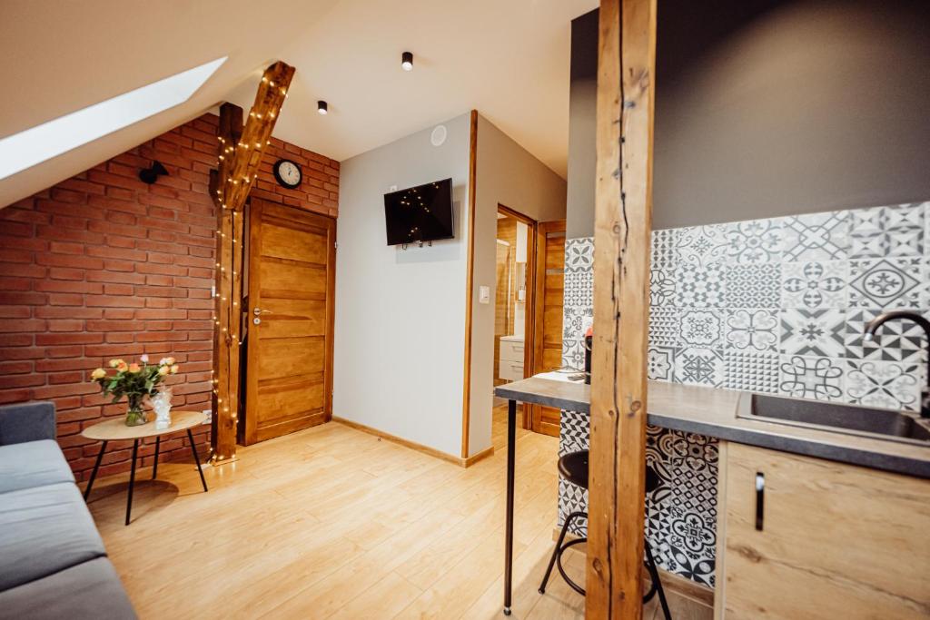 a room with a kitchen with a counter and a staircase at Apartamenty Przygoda w Karpaczu in Karpacz