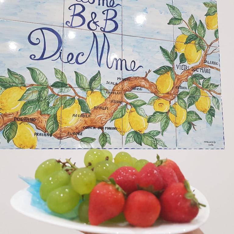a plate of fruit with a sign in the background at B&B DieMme Amalfi Coast in Vietri sul Mare