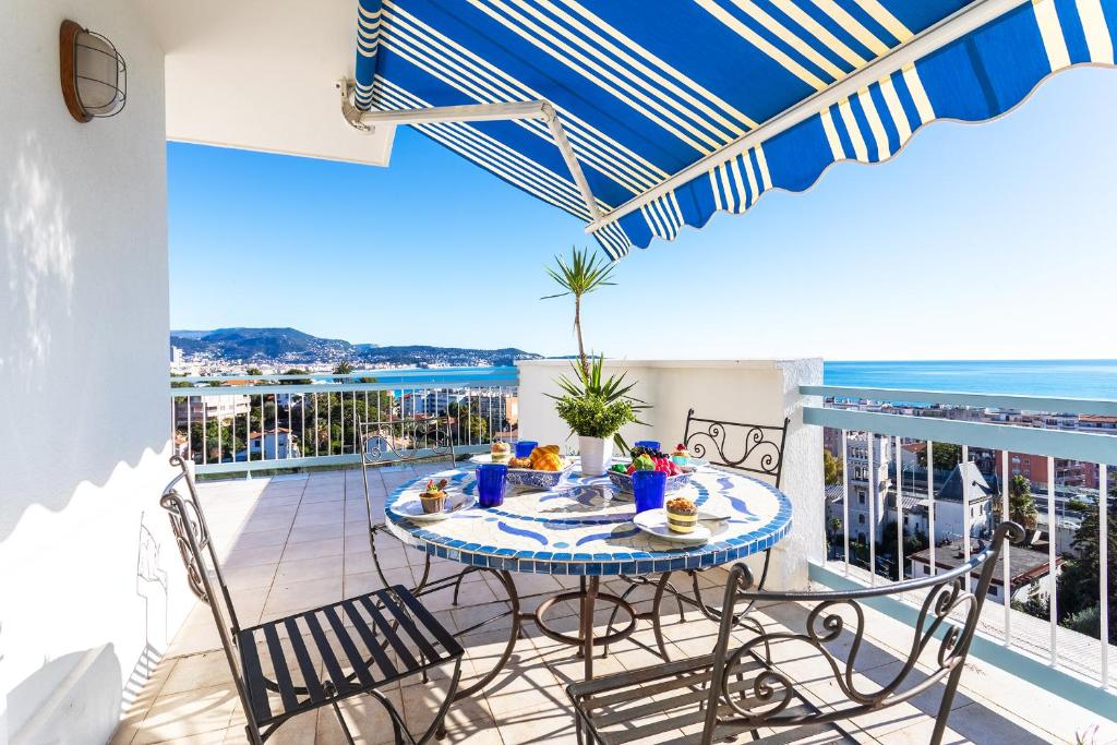 un balcon avec une table et des chaises et l'océan dans l'établissement VUE DES ANGES AP4238 By Riviera Holiday Homes, à Nice