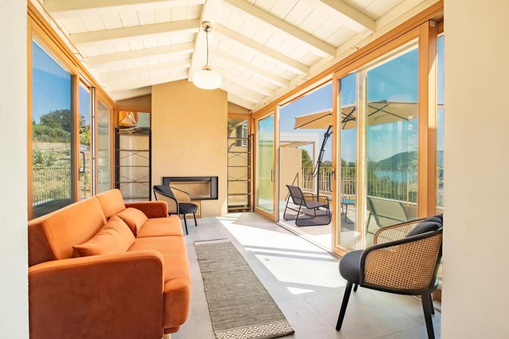 a living room with a couch and chairs and windows at Baia di Spartaia 1 in Procchio