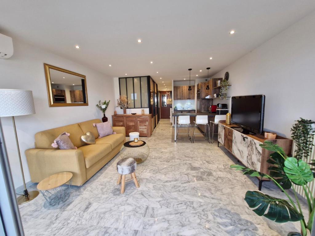 Il comprend un salon doté d'un canapé et d'une télévision. dans l'établissement Sunny and cosy sea view studio, à Antibes