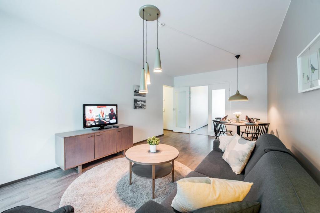 a living room with a couch and a tv at Forenom Serviced Apartments Helsinki Lapinlahdenkatu in Helsinki