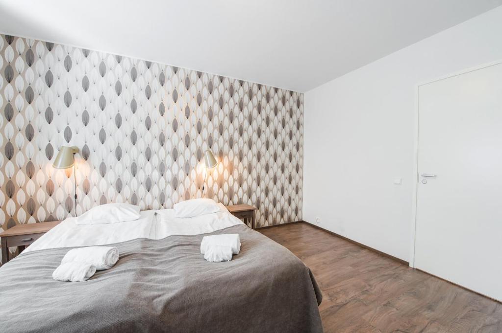 a bedroom with a bed with two white towels at Forenom Serviced Apartments Helsinki Lapinlahdenkatu in Helsinki
