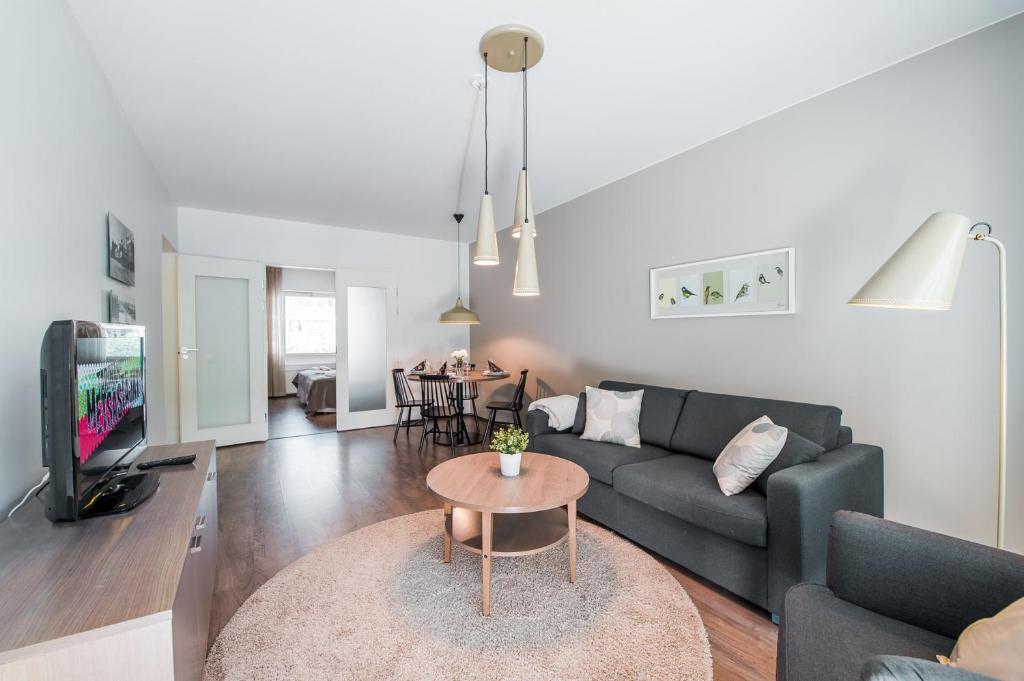 a living room with a couch and a table at Forenom Serviced Apartments Helsinki Lapinlahdenkatu in Helsinki