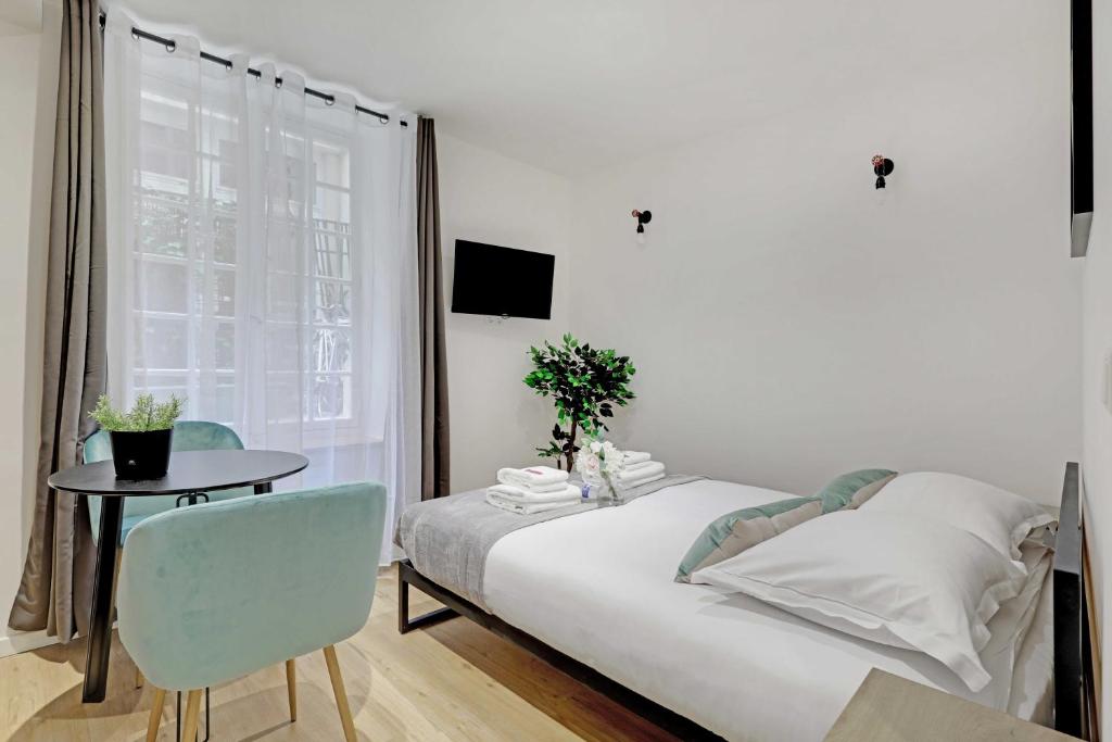 a bedroom with a bed and a table and a window at Cozy studio -2P- Sorbonne Institute- Latin quarter in Paris