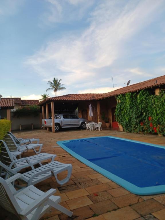a pool with lounge chairs and a house at Flat confortável in Brasilia