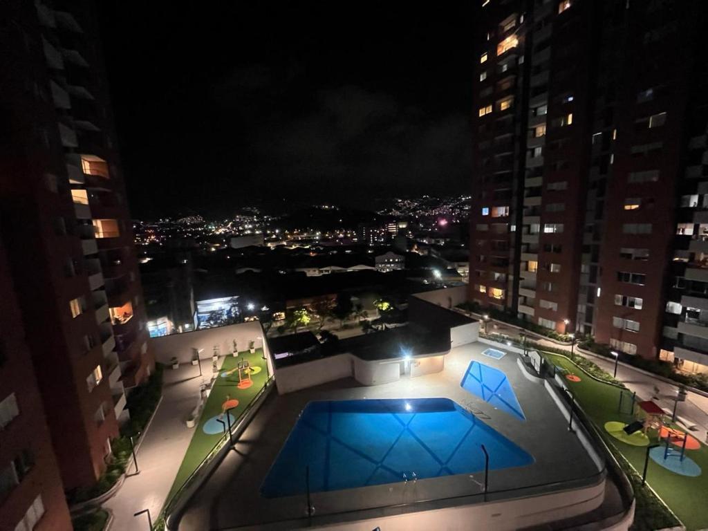 a view of a building with a pool at night at Hermoso apto en poblado con piscina in Medellín