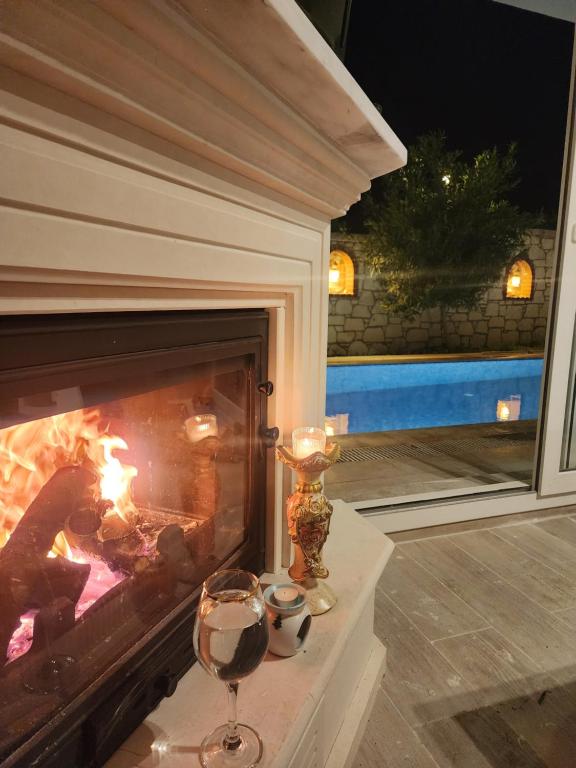 una copa de vino junto a la chimenea en Evalacati - Villa Harnup- Tamamen Müstakil Villa, en Alacati