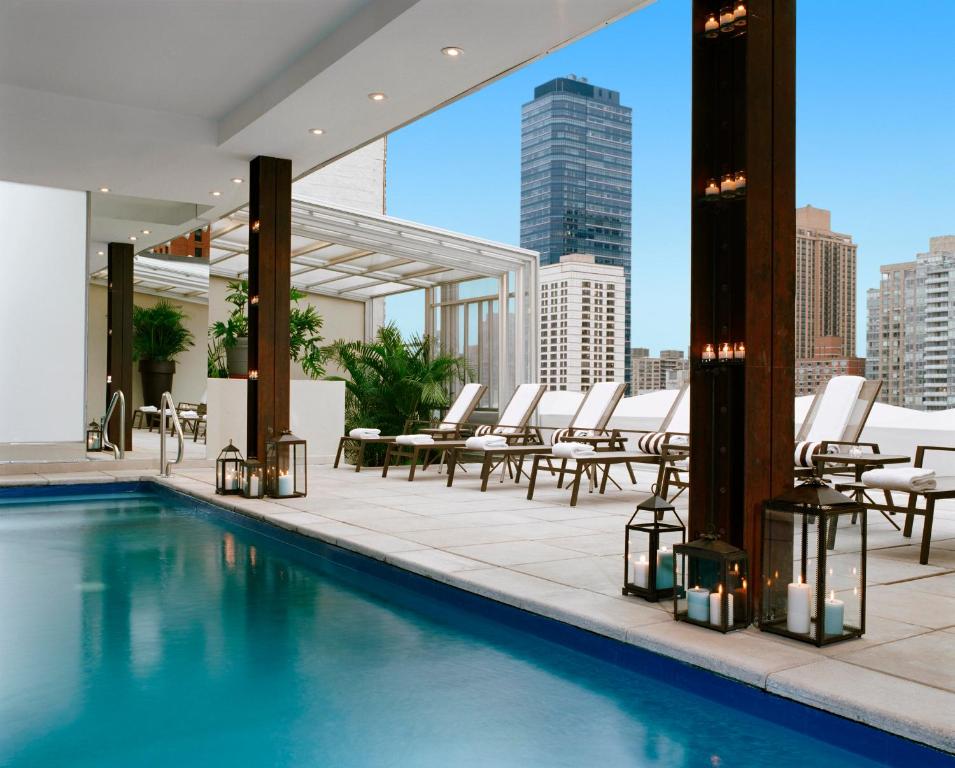 a hotel room with a pool, chairs, and tables at Empire Hotel in New York