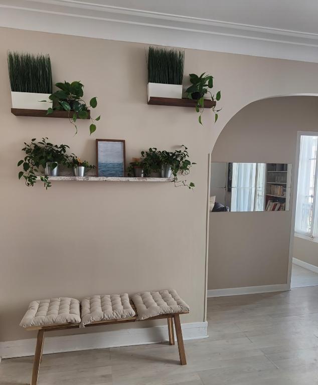 un banc dans une pièce avec des plantes sur le mur dans l'établissement La Fourche, à Paris