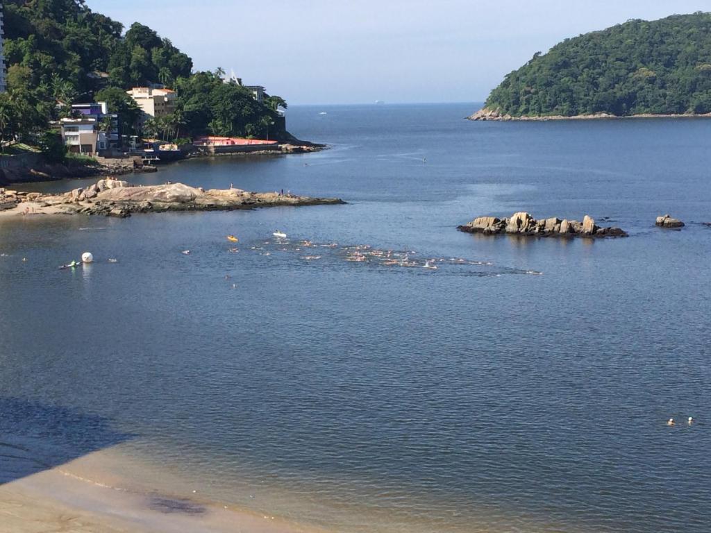 a body of water with a group of rocks in it at apartamento sao vicente vista mar pe na areia in São Vicente