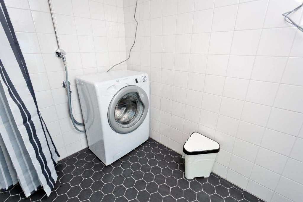 a washing machine in a bathroom with a toilet at Forenom Serviced Apartments Helsinki Kruununhaka in Helsinki